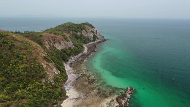 Aerial view of ocean waves, beach and rocky coastline and beautiful forest of Koh Larn, Pattaya, Thailand . Beautiful nature background.