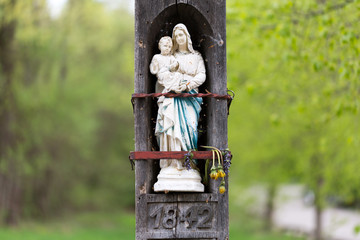 Statue of holy virgin mary (Heilige Jungfrau Maria) / Madonna holding her child Jesus in her arms. The inscription below the statue reads 1842.