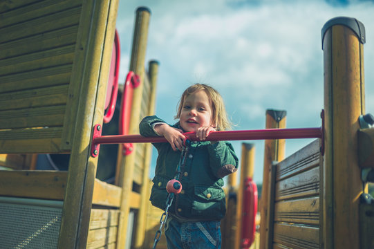 Little toddler on play equipment in the playground
