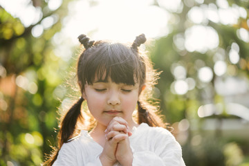 little girl praying. kid prays. Gesture of faith.Hands folded in prayer concept for...