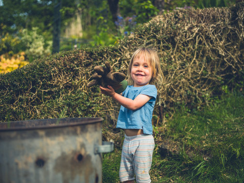 Little toddler putting weeds in an incinerator