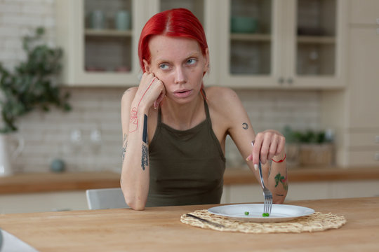 Skinny woman with bulimia eating only three green peas
