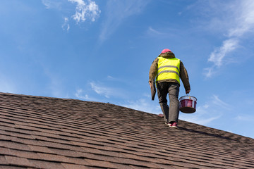 Workman standing on tile roof of new home under construction