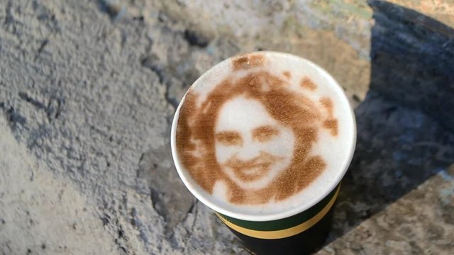 Drawing of a woman's face on a foam coffee latte