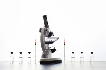 Research laboratory. Test tubes and microscope on the table on a white background.