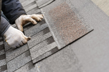 Workman install tile on roof of new house under construction