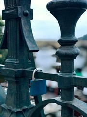 Metal fence with padlocks overlooking a river
