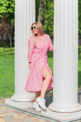 Young stylish woman walking on the city street at summer. Casual fashion, linen dress look. Plus...