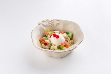 Fresh fruit salad with ice cream and red currant isolated on white background