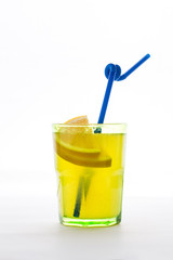 yellow transparent cocktail in glass with orange slices and straw isolated white background