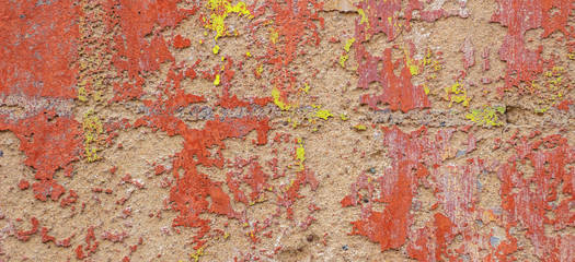 Old cracked weathered shabby red yellow painted plastered peeled wall banner background.