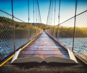 Wooden suspension bridge on the pages of book