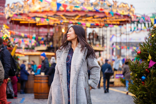 Happy asian woman in winter coat from faux fur