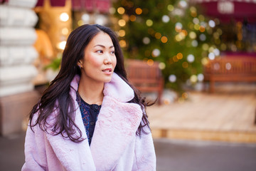 Obraz premium Happy asian woman in winter coat from faux fur