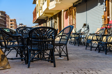 Empty tables and chairs in a street cafe