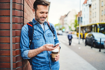 Portrait of man talking on phone through wireless headphones out in the city