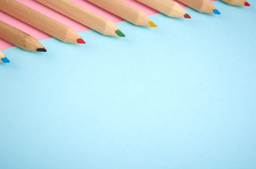 Wooden color pencils on blue background, flat lay