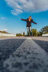 Beauty blonde young woman walk on middle of street in jacket