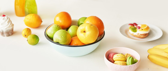 Fruits: apples, watermelon, pineapple, bananas, lemons, oranges on the table, warm loft-style kitchen