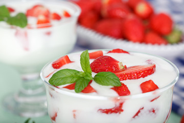 Strawberry flavored yoghurt with fresh berries and mint leaves. Healthy food for breakfast.