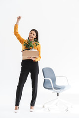 Obraz premium Full length portrait of employed young woman dressed in elegant wear holding box with office supplies due to hiring