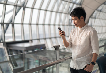 man waiting for flight and using smart phone in airport