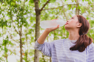 Beautiful young women, Asian athletes, drinking water after a jogging exercise that is tired, lost energy.