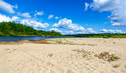 Wild sandy beach, only sand, river and thick clouds