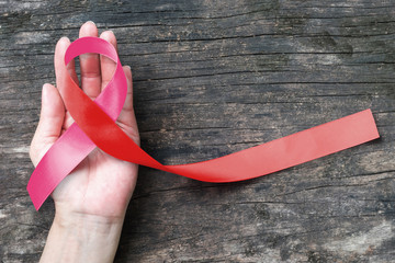 Pink ribbon - Red ribbon (isolated with clipping path) on symbolic color bow for HIV AIDS and breast, cervical cancer disease awareness - obrazy, fototapety, plakaty