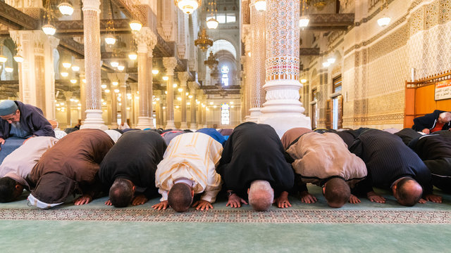 Muslim men bowing, kneeling and praying inside of a big mosque in Constantine, Algeria