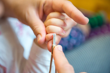 Mother is cutting nail.