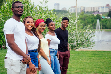 group of five smiling african-american men and women walking outside cloudy weather near the lake,exchange students in Russia
