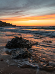 Reddish sunset light reflecting on the sandy beach