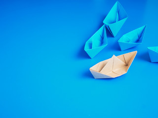 Leadership concept origami boat paper