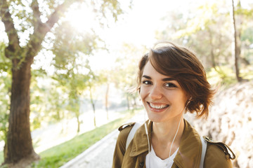 Happy amazing woman walking outdoors in park in beautiful spring day.