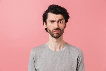 Handsome young confused bearded brunette man