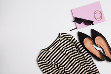 Stylish feminine outfit with striped black and white dress and suede shoes