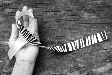 Carcinoid Cancer Awareness ribbon zebra stripe printed pattern on helping hand