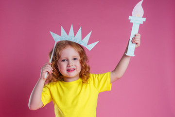 redhead ginger charming female kid celebration independence holding a paper torch and diy crown on...