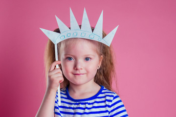 redhead blonde charming female kid celebration independence holding a paper torch and diy crown on...