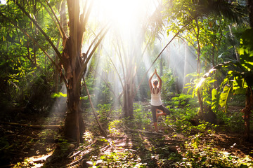 woman doing yoga outside in jungle