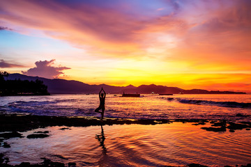 Caucasian woman practicing yoga at seashore