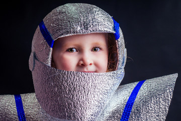 Little girl in foil diy space suit on a black background in the studio July 20, 1969 day of landing...