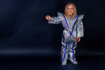 Little girl in foil diy space suit on a black background in the studio July 20, 1969 day of landing...