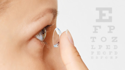 Young woman puts contact lens in her eye. Eyewear, eyesight and vision, eye care and health,...