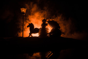 Artwork decoration. Silhouette of old coach with horse on dark toned foggy background.