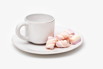 Delicious sweet dessert.  Marshmallow and cup of coffee on table. Zephyr on white plate.