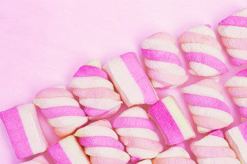 Gentle pink and yellow color marshmallows on pink background with copy space. Sweet food. Pastel color.