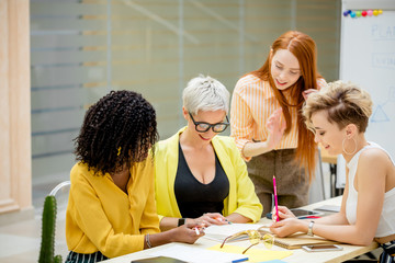 group of young female people have met to suggest of new ideas for possible development. international brainstorming workshop