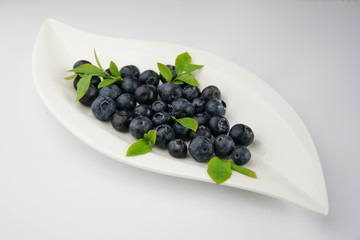 Owoce borówki z liśćmi na talerzyku blueberry